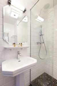 a white bathroom with a sink and a shower at Ambassadeurs Logis Hotel in Saint Malo