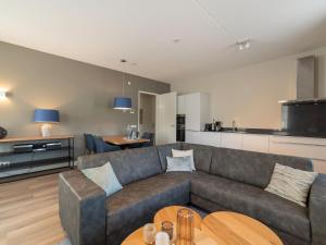 a living room with a couch and a table at Premium apartment with private wellness in Zeeland in Colijnsplaat