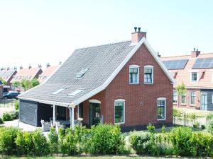 uma casa de tijolos vermelhos com painéis solares no telhado em Vacation home with sauna in Zeeland em Colijnsplaat