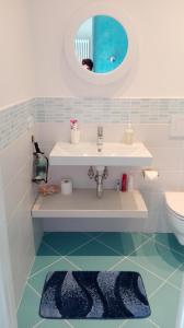 ein Badezimmer mit einem Waschbecken, einem WC und einem Spiegel in der Unterkunft La Casa di Mà in Piancastagnaio