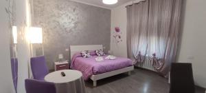 a bedroom with a purple bed and purple chairs at La Casa di Mà in Piancastagnaio