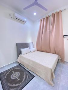 a bedroom with a bed with a ceiling fan at CIKNA’s TINY HOUSE in Kuala Terengganu