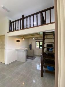 a kitchen with a loft with a staircase and a desk at CIKNA’s TINY HOUSE in Kuala Terengganu