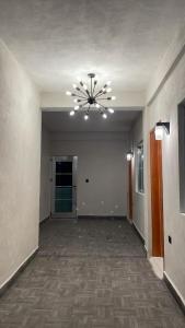 un pasillo vacío con una lámpara de araña en un edificio en Posadas LUZ DE MAR, en Dzilam de Bravo
