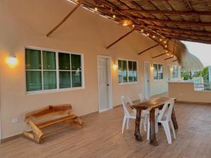 a dining room with a wooden table and chairs at Posadas LUZ DE MAR in Dzilam de Bravo