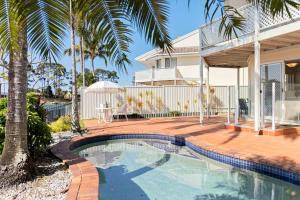 una casa con piscina di fronte a una casa di 64 Isle of Palms a Gold Coast