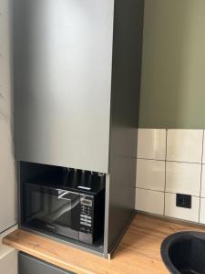 a kitchen with a black microwave on a counter at Aparthotel Old Avenue in Tbilisi City