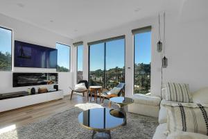 Luxury hilltop retreat, majestic views and hot tub في لوس أنجلوس: غرفة معيشة مع أريكة وتلفزيون