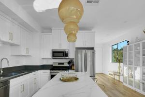 eine weiße Küche mit einem Tisch und einer Schüssel darauf in der Unterkunft Luxury hilltop retreat, majestic views and hot tub in Los Angeles