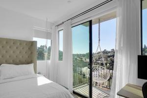 洛杉磯的住宿－Luxury hilltop retreat, majestic views and hot tub，一间卧室设有一张床和一个大窗户
