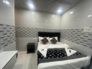 a bedroom with a bed with white sheets and pillows at Hotel Sai Residency in Mumbai