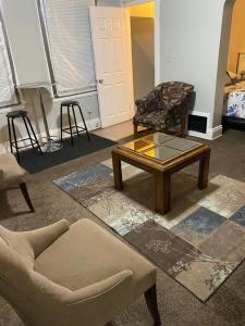 ein Wohnzimmer mit Couchtisch und Stühlen in der Unterkunft Charming 3 bedroom apartment midtown in Cincinnati