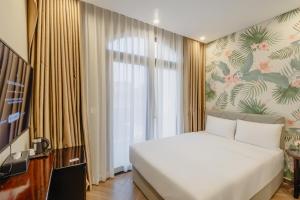 a bedroom with a bed and a large window at Tropical Bay Grand World Phu Quoc in Phu Quoc