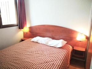 ein Schlafzimmer mit einem Bett mit zwei Lampen in der Unterkunft Résidence Pic Du Midi - 3 Pièces pour 7 Personnes 614 in La Mongie