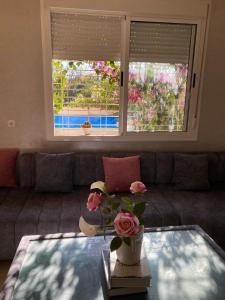 ein Wohnzimmer mit einem Sofa und einem Tisch mit Blumen darauf in der Unterkunft Spacious and Cozy Villa for Peace of Mind, Saidia in Saidia 