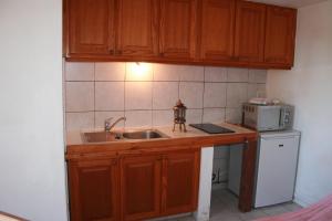 a kitchen with a sink and a microwave at La Coccinelle in Île du Levant +36 photos