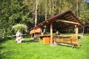 a wooden pavilion with a bench in the grass at Pokoje Na Skalicy in Ustroń