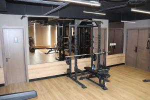 a gym with several tread machines in a room at Liyaqat Airport Residence in Muscat
