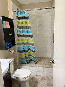 a bathroom with a shower curtain and a toilet at Pelican hut in Panama City