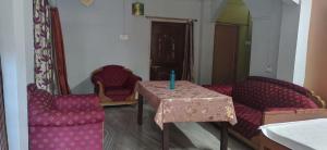 een woonkamer met een tafel en 2 stoelen bij Comfort Inn Kamakhya Jn in Guwahati
