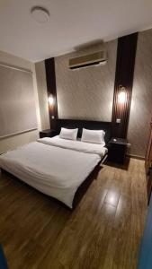 um quarto com uma cama grande e lençóis brancos em درة العروس شاليه شاطئ البرادايس em Durat Alarous