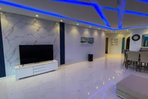 sala de estar con TV de pantalla plana en la pared en درة العروس شاليه شاطئ البرادايس en Durat  Alarous
