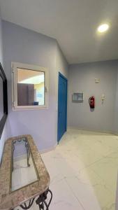 ein leeres Zimmer mit einer blauen Tür und einem Spiegel in der Unterkunft درة العروس شاليه شاطئ البرادايس in Durrat Al-Arus