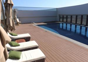 a swimming pool on the deck of a building at Liyaqat Airport Residence in Muscat