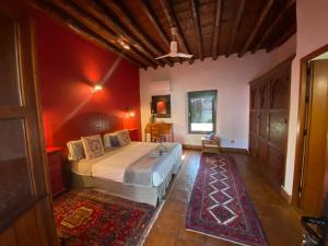 a bedroom with a large bed with red walls at La Guzmana de Ronda in Ronda