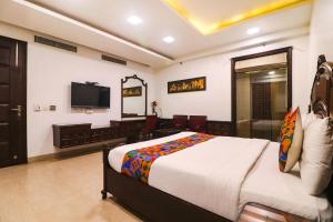 a bedroom with a bed and a desk and a television at FabHotel Prime Zewarat Inn in New Delhi