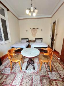 アレクサンドリアにあるARAB Hostel For Men onlyغرف خاصة للرجال فقط 仅限男士 女士不允许のベッド2台、テーブル、椅子が備わる客室です。
