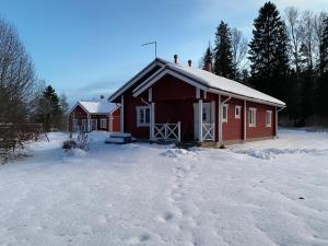ein rotes Gebäude mit Schnee auf dem Boden davor in der Unterkunft Lomakivi in Kausala