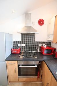 een keuken met een fornuis top oven naast een koelkast bij Contemporary 2 bed flat in Bristol, Free Parking in Bristol