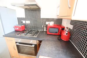 a small kitchen with a red microwave on a counter at Contemporary 2 bed flat in Bristol, Free Parking in Bristol