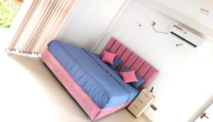 a bedroom with a bed with blue and pink pillows at Luxe Diamond Villa in Matara