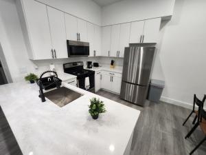 a kitchen with white cabinets and a stainless steel refrigerator at Luxury 2 bedroom apartment, close to NYC! in Bayonne