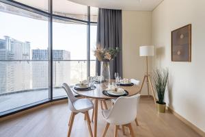 a dining room with a table and chairs and a large window at Frank Porter - RP Heights in Dubai