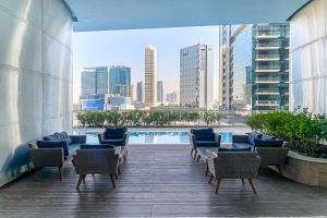 a balcony with chairs and a pool on a building at Frank Porter - RP Heights in Dubai