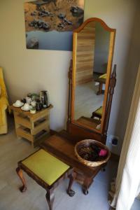 einen Spiegel und einen Tisch und einen Stuhl in einem Zimmer in der Unterkunft Gemstone Farm in Plettenberg Bay