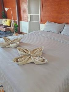 Una cama blanca con dos almohadas de arco. en Private riverview in the nature en Chiang Khan