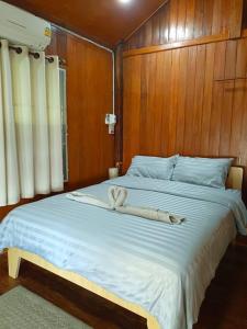 Una cama grande con dos toallas blancas. en Private riverview in the nature en Chiang Khan