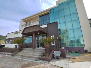 a large building with a staircase in front of it at Seongsan Sunrise Pension in Seogwipo