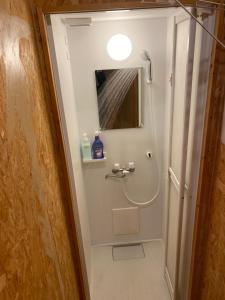 a bathroom with a shower with a toilet and a mirror at Gasthaus 44 Higashimikuni in Osaka