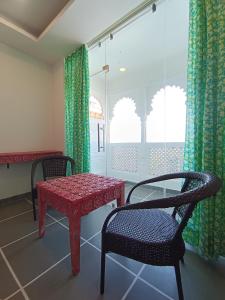 a table and a chair in a room with a window at Hotel Mewari Villa in Udaipur