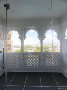 a bathroom with a window with a view of a river at Hotel Mewari Villa in Udaipur