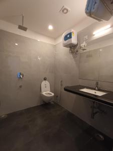 a bathroom with a toilet and a sink and a mirror at Hotel Mewari Villa in Udaipur