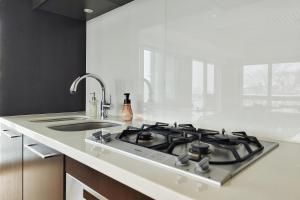 a kitchen with a stove and a sink at Alpen Ridge in Niseko