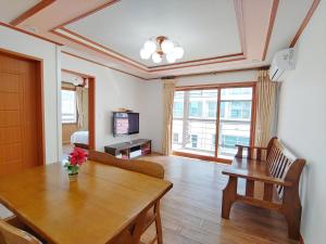 a living room with a wooden table and a dining room at Seongsan Sunrise Pension in Seogwipo