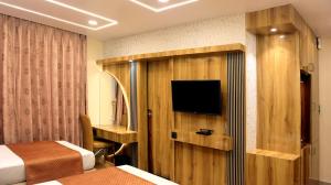 a hotel room with a television and a bed and a desk at Hotel Executive Tower in Kolkata