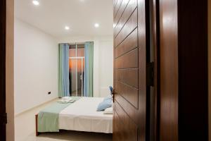 małą sypialnię z łóżkiem i drzwiami w obiekcie Anu - The Breeze of Heaven w mieście Kandy